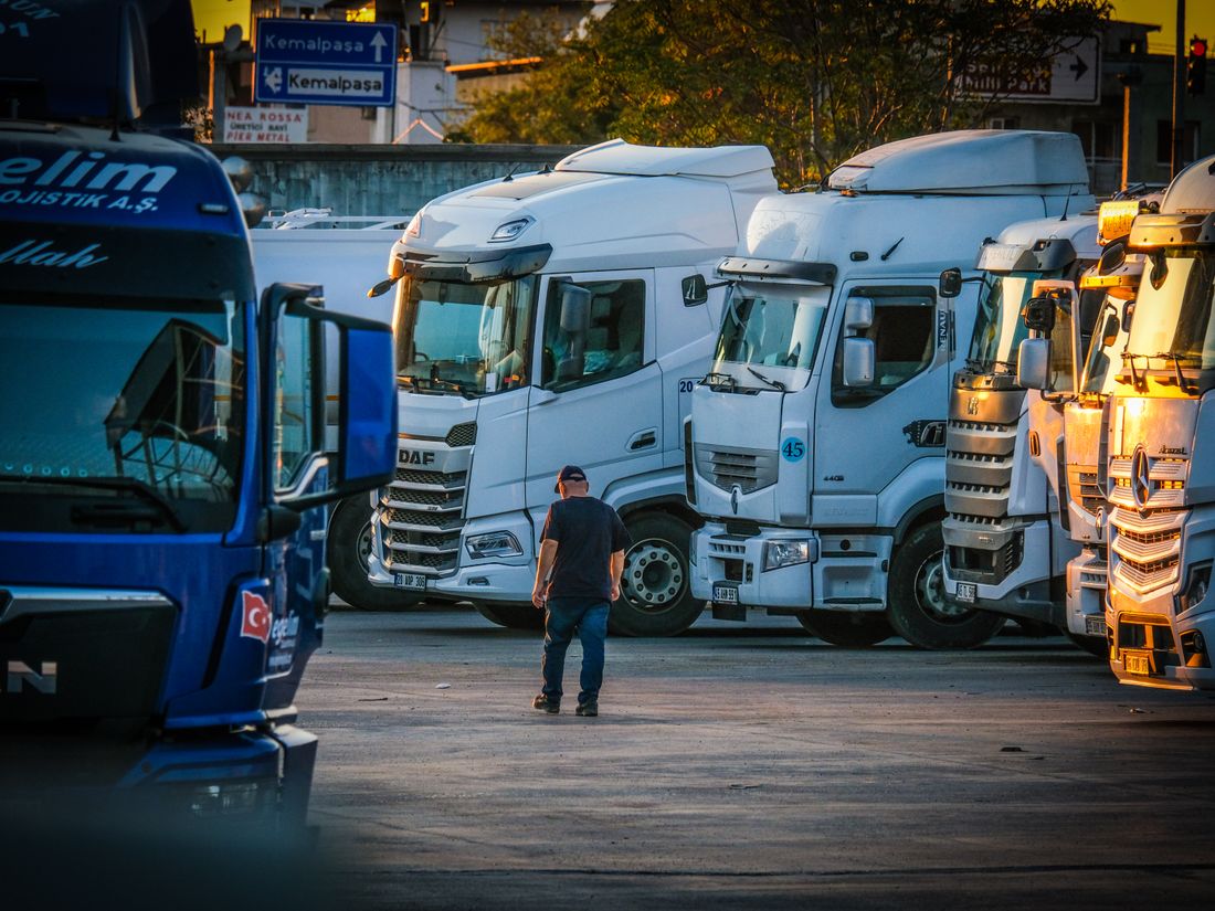 A semi truck driver beside their rig